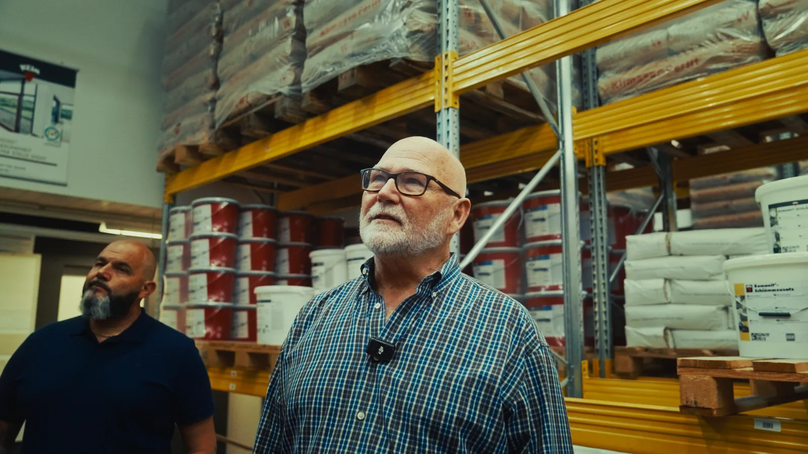 Two owners talking in their paint warehouse.