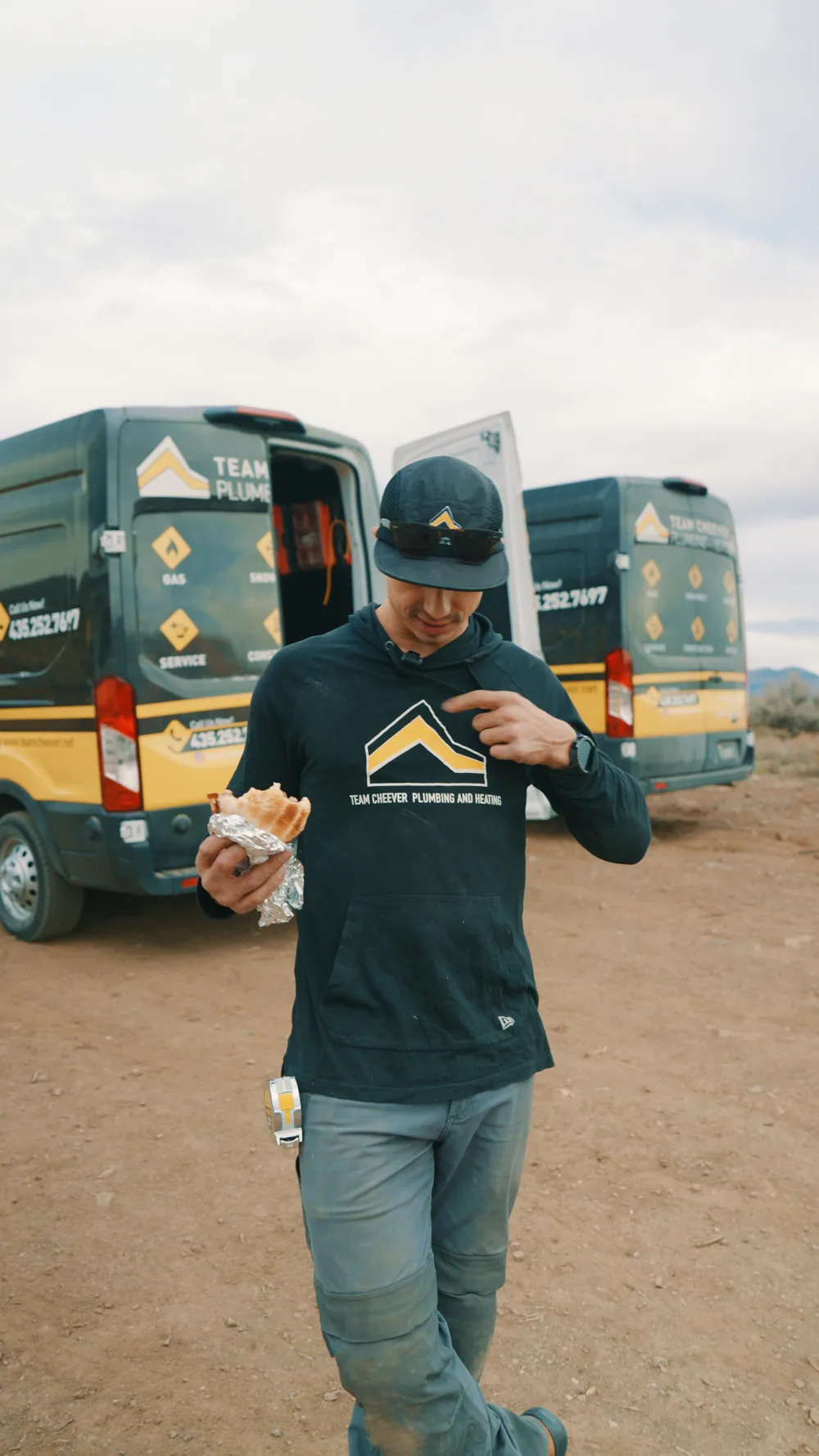 A plumber walking past the company work vans.